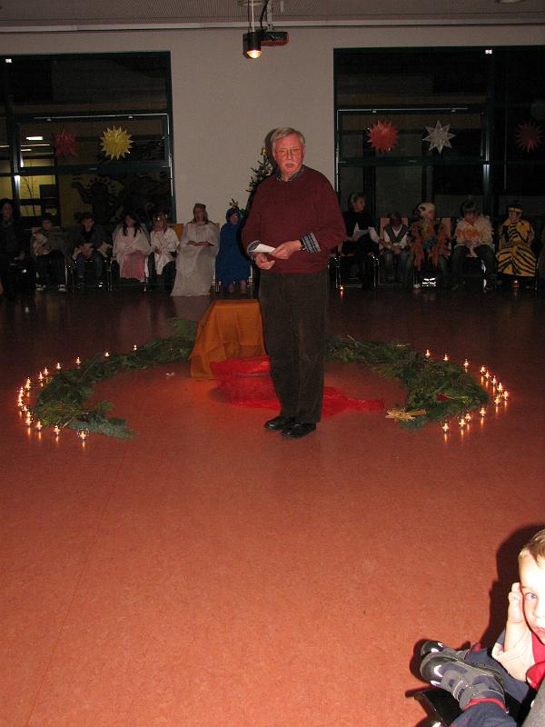 IMG_8990.JPG - Zu Gast in der Gutneberg-Schule: Ein Mitorganisator des Lebendigen Adventskalenders begrüßt die sehr gut gefüllte und im Kerzenlicht erstrahlende Mensa.